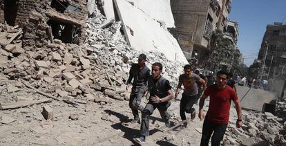 Un grupo de sirios corre a refugiarse durante un bombardeo en Duma este viernes.