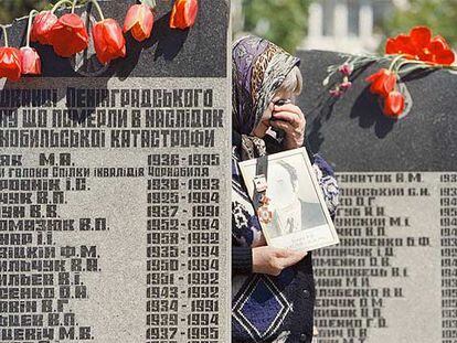 Una viuda llora a su marido ante el monumento erigido en Kiev en memoria de los fallecidos por el accidente nuclear de Chernóbil.