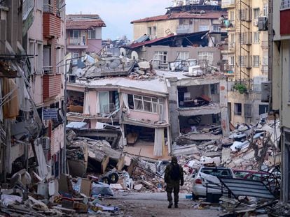 Un soldado turco camina entre los escombros de los edificios colapsados tras los terremotos, este domingo en Hatay.
