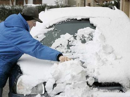 Un conductor retira la nieve de su coche ayer por la mañana en Araia (Álava).