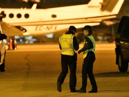 Miembros de la Guardia Civil buscan al grupo de pasajeros que ha abandonado un avión y ha invadido una de las pistas del aeropuerto de Palma este viernes.