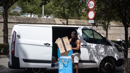 Un repartidor de Amazon organiza los paquetes junto a la furgoneta en el barrio de la Bordeta (Barcelona) en una imagen de archivo de 2022.