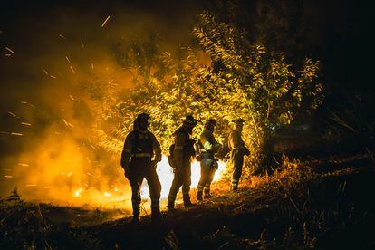 Operarios de las Brigadas de Refuerzo de Incendios Forestales (BRIF) luchan contra las llamas en la madrugada del sábado en la parroquia de Cures.