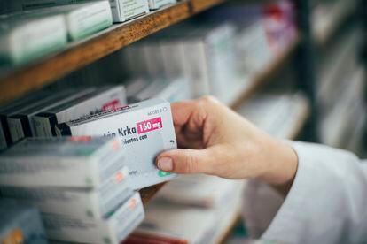 Un farmaceutico dispensa medicamentos en una botica de Galicia.