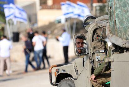 Un soldado israelí custodia a un grupo de colonos judíos durante una gira por la ciudad vieja de Hebrón en Cisjordania, antes de la festividad judía de Hanukkah, también conocida como la Fiesta de Luces.