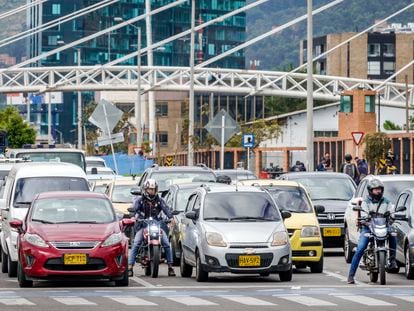 Automovilistas y motociclistas esperan en un cruce en Bogotá.