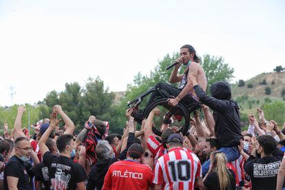 Un seguidor del Atlético en sillas de ruedas es aupado durante la celebración en Valladolid.