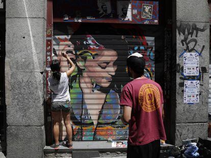 Dos artistas pintan un grafiti en Malasaña.