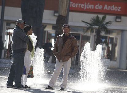 Vecinos conversando en la plaza de España, en el centro de Torrejón.