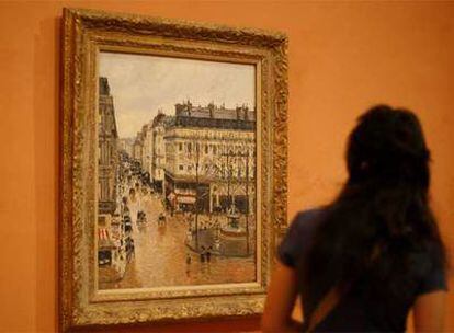 Una visitante del Museo Thyssen de Madrid contempla <i>Rue Saint Honoré aprês-midi. Effet de pluie</i>, de Pissarro.