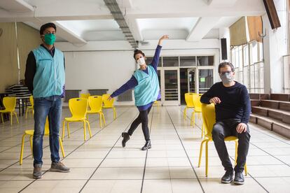 El director del Insituto Superior de Arte, Marcelo Birman (sentado); el coordinador del ballet del Teatro Colón, Uriel Ortiz; y la bailarina Ayelén Sánchez en un salón del vacunatorio, el 23 de abril.