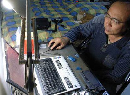El <i>bloguero</i> chino Zhang Shihe, conocido como <i>Templo del tigre</i>, ante el ordenador, en su apartamento.