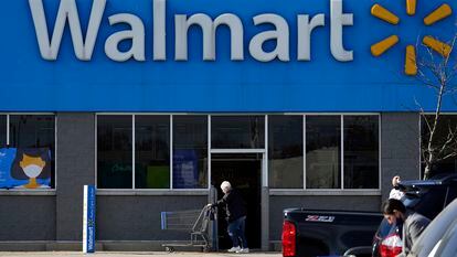 Una mujer pasa con un carro de la compra por delante de una tienda de Walmart en Illinois.