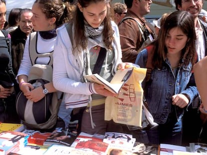 Varios visitantes en uno de los puestos de las librer&iacute;as por Sant Jordi, en 2017 en Barcelona.