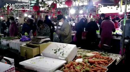 Compradores portan mascarillas en un mercado de la ciudad de Wuhan, en China.