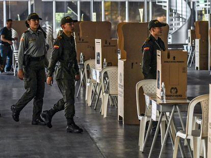 Unos agentes de la Policía resguardan un puesto electoral en Medellín.