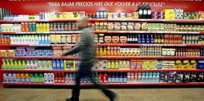 Un hombre pasa ante las estanterias de un supermercado. 