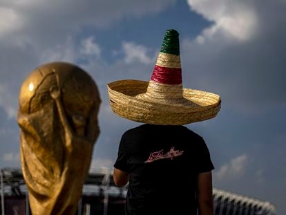 Un seguidor de la selección mexicana, junto a una réplica del trofeo de la Copa del Mundo, en Doha (Qatar).