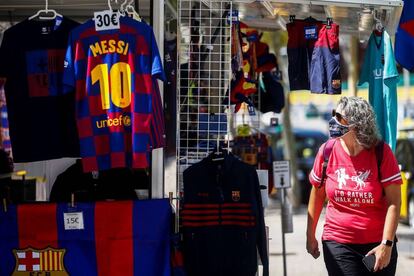 Una persona mirant una samarreta de Leo Messi en una parada prop del Camp Nou.