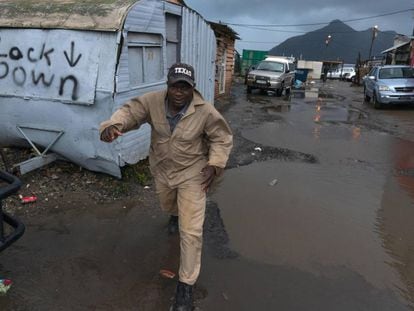 Ciudad del Cabo, en Sudáfrica. Un hombre corre por las calles inundadas del suburbio de Masiphumelele, donde están sufriendo un clima invernal, con fuertes lluvias y viento, en estos días de junio ya de desconfinamiento.