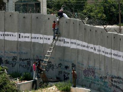 Varias personas intentan saltar el muro en los alrededores de Jerusal&eacute;n.