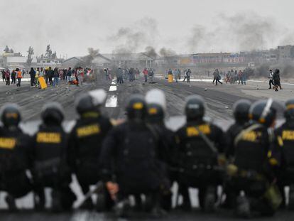 Varios policías observan a un grupo de manifestantes en el aeropuerto Alfredo Rodríguez Ballón, en Arequipa (Perú).