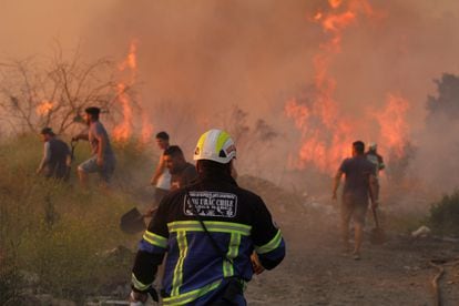 Además del de Curacavi, los incendios se concentran en las regiones de Valparaíso, situada a 120 kilómetros al oeste de Santiago, y Biobío, a 500 kilómetros al sur. En la imagen, bomberos y voluntarios combaten un incendio en Santa Rosa de Colmo, en la región de Valparaiso, el 11 de diciembre de 2022.