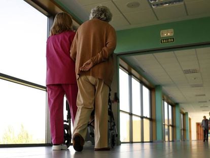 Una trabajadora pasea junto a una anciana en el centro de referencia de atención a personas con alzhéimer y demencia, en Salamanca.  