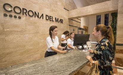 Sabina Urraca atiende a una cliente en la recepción de un hotel de Benidorm.