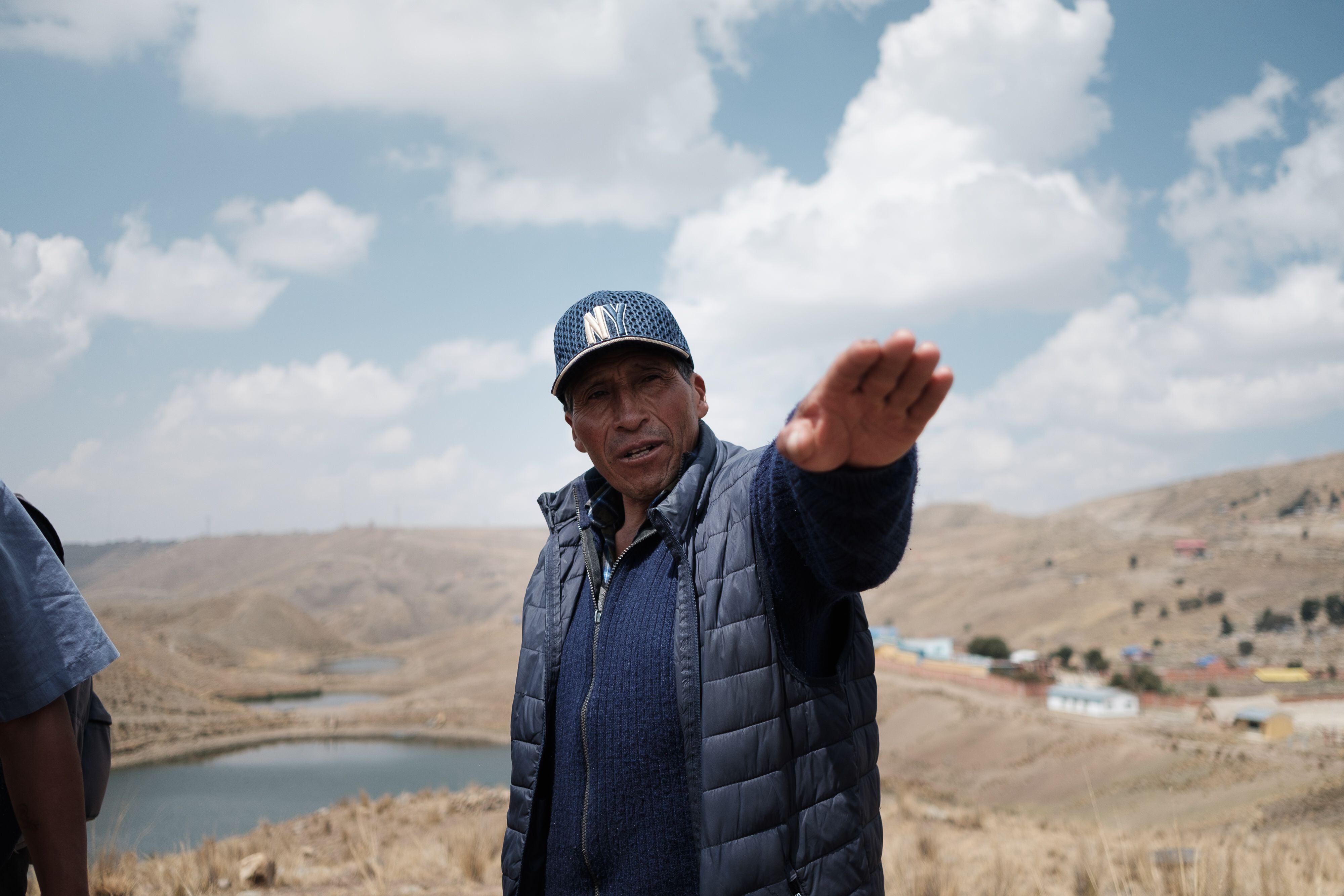 Erasmo Persona, habitante de la comunidad de Siete Lagunas, en el altiplano boliviano, conversa sobre la sequía que afecta al lugar, con tres de las lagunas que dan nombre a la comunidad a sus espaldas.