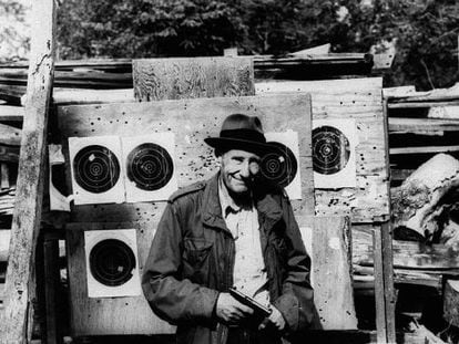 El escritor William S. Burroughs, fotografiado con una pistola y unas dianas de tiro al blanco.