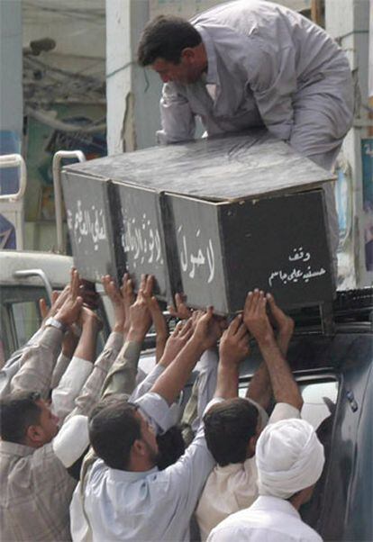 Varios iraquíes cargan el ataúd de la víctima de la explosión de un coche bomba en Bagdad