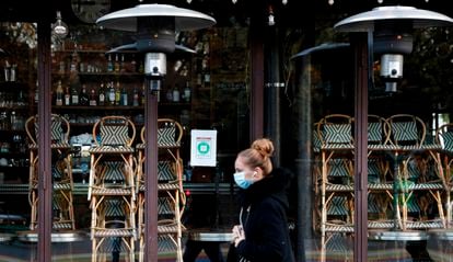 Una mujer pasa, la semana pasada, frente a la puerta de un restaurante cerrado en París.