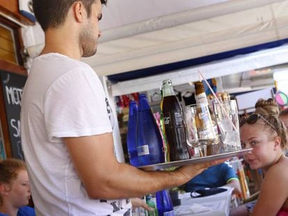 Un camarero sirve a un grupo de turistas en la terraza de un restaurante en la Alcudia, Mallorca. 