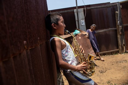 Zaachila, Oaxaca. Ángel y Juana viven en una habitación de chapa construida sobre un descampado. En su casa, Ángel toca el saxofón ante la atenta mirada de su prima. ‘Ángeles Azules’ es su canción favorita. “Cuando acabe mi tratamiento volveré a clases de saxofón”, cuenta el pequeño, que quiere ser músico cuando crezca.