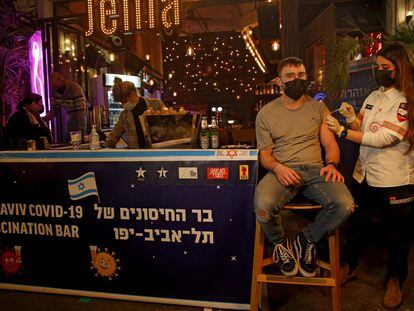 Una sanitaria administra una vacuna contra la covid en un bar de Tel Aviv.