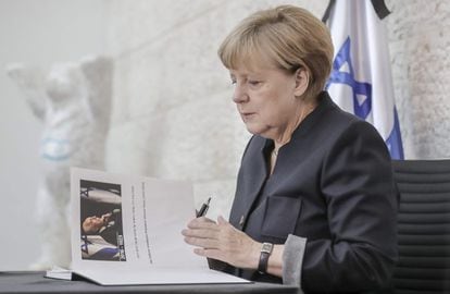 La canciller alemana, Angela Merkel, firma en el libro de condolencias por el expresidente israelí y Nobel de la Paz, Simón Peres, en la embajada de Israel en Berlín (Alemania).