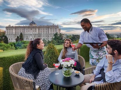 Un grupo de amigos disfruta de las vistas del Palacio Real en la la terraza de los Apartosuites Jardines de Sabatini, en Madrid.