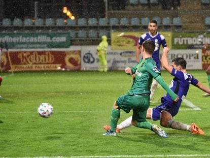 El delantero de la Real Ander Barrenetxea (centro) remata un balón ante Diego Martín (derecha), del Becerril, durante el partido de Copa disputado este jueves en el estadio Nueva Balastera, en Palencia.