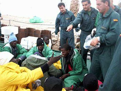 Guardias civiles de la <i>Río Duero</i> dan alimentos a los senegaleses hallados el martes a la deriva en Cabo Blanco.