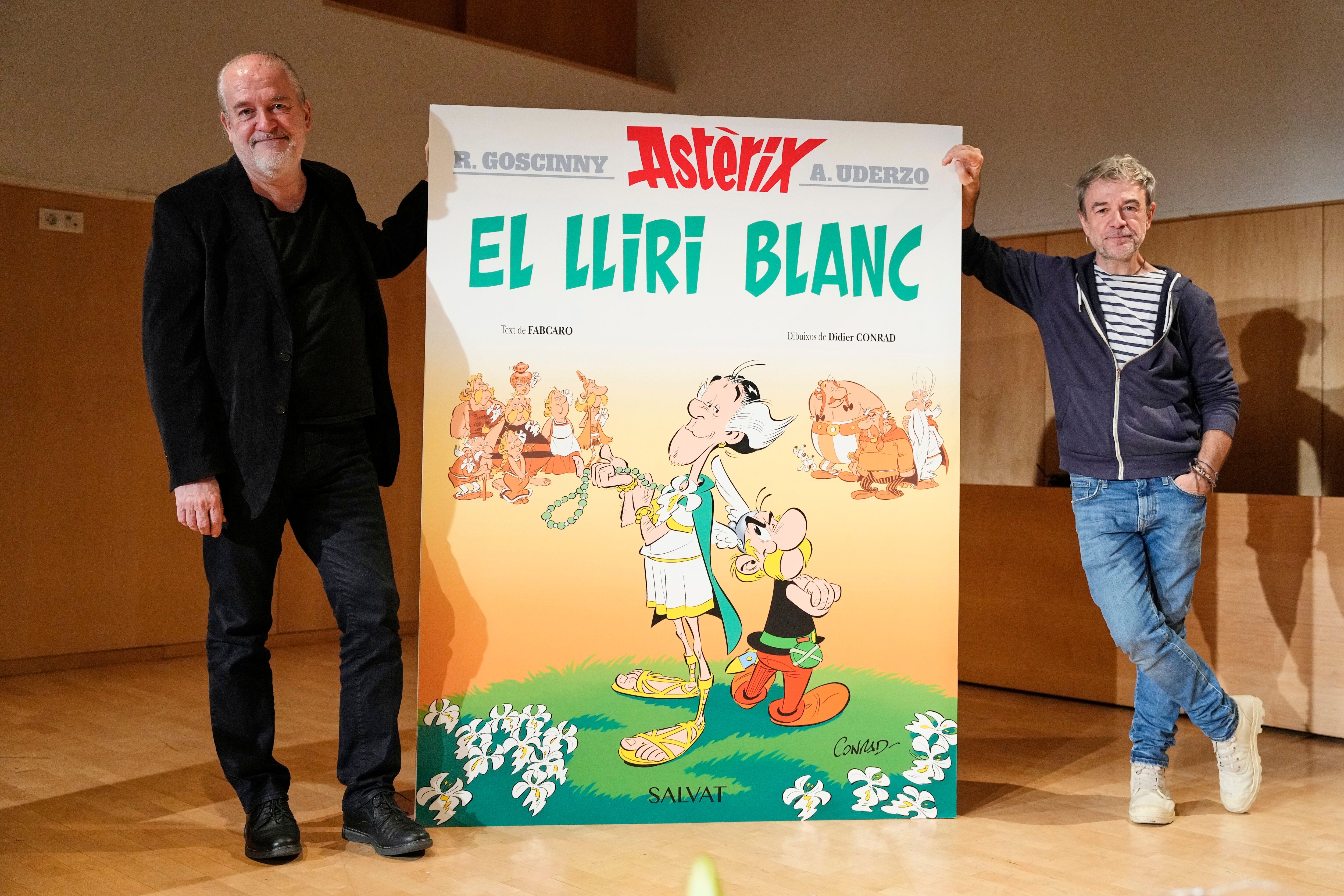 Didier Conrad y el nuevo guionista de la serie, Fabrice Caro, a la derecha, con la edición catalana del nuevo álbum de Astérix, 'El lirio blanco'.