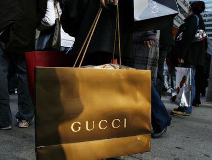 Una persona con una bolsa de Gucci.