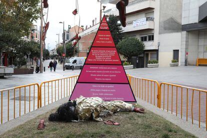 La maniquí junto a la pirámide de la discriminación.