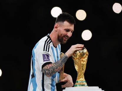 Lionel Messi toca la copa del mundo después de que la selección Argentina venciera por penaltis a Francia en la final del mundial de Qatar 2022.