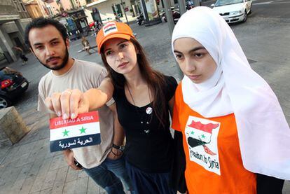 De derecha a izquierda, Asma Rostom, Layla Jandali y Amjad Taleb muestran los emblemas de la Asociación de Ayuda al Pueblo Sirio.
