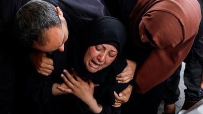 Una mujer llora junto a los cuerpos sin vida de unos palestinos asesinados por un bombardeo israelí en Rafah este martes.