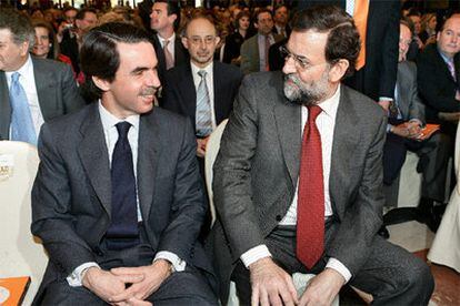 Aznar y Rajoy charlan durante el acto de la FAES en Madrid.