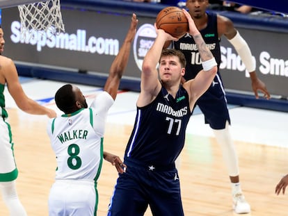 Doncic lanza un triple pese a la oposición de Kemba Walker.