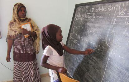 Aisha sale a la pizarra en la escuela para niños víctimas de la esclavitud de Tarhil ante la atenta mirada de su profesora Belly Diallo.