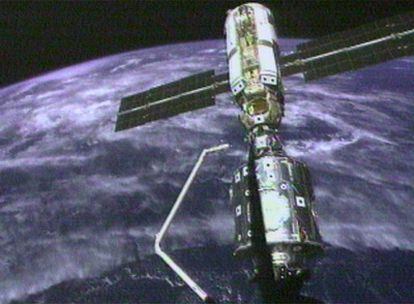 Fotograma de archivo tomada el 6 de diciembre de 1998 en la que se ve el brazo robot del Endeavour encaminándose al módulo Zarya , en el primer ensamblaje con la Estación Espacial Internacional (NASA TV)